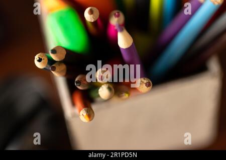 Farbige Stifte und Stifte im Topf auf dem Schreibtisch zu Hause, selektive Fokussierung Stockfoto