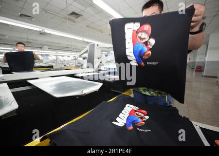 QINGDAO, CHINA - 15. MAI 2023 - Arbeiter stellen Bekleidungsartikel für den Export ins Ausland in einem Bekleidungsgeschäft in Qingdao, Ostchina Provinz Shandong, im Mai her Stockfoto