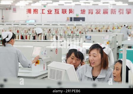 QINGDAO, CHINA - 15. MAI 2023 - Arbeiter stellen Bekleidungsartikel für den Export ins Ausland in einem Bekleidungsgeschäft in Qingdao, Ostchina Provinz Shandong, im Mai her Stockfoto