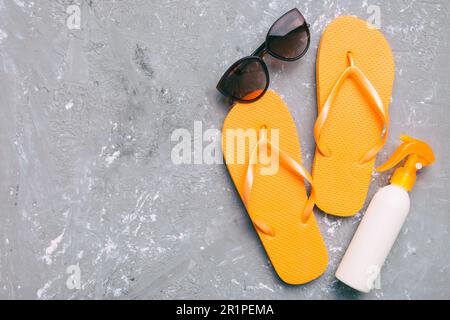 Reisekonzept für den Sommer. Flip Flops, Sonnenbrillen und Seesterne auf Weiß. Draufsicht auf farbigem Hintergrund. Stockfoto