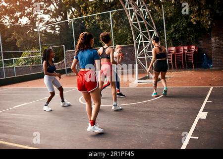 Sie haben eine gute Verteidigung. Eine vielfältige Gruppe von Sportlerinnen, die tagsüber gemeinsam ein Wettkampfspiel mit Basketball spielen. Stockfoto
