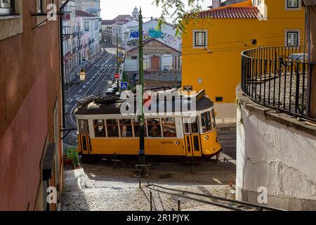 Blick auf den Platz Largo das Portas do sol mit alter gelber Straßenbahn im mittelalterlichen Viertel Alfama in Lissabon, sonniger Tag, blauer Himmel. Stockfoto