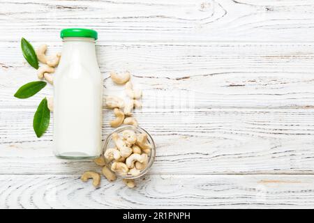 Vegane Milch aus Cashews in Flaschen auf einem Holztisch, vegetarische Alternative Lebensmittel, sauberes Esskonzept. Draufsicht mit Kopierbereich. Stockfoto