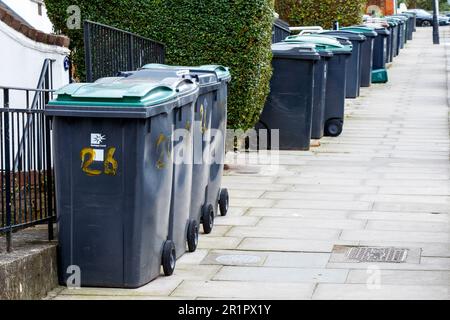 Mülltonnen aus Kunststoff säumen eine Wohnstraße in Haringey, North London, Großbritannien Stockfoto