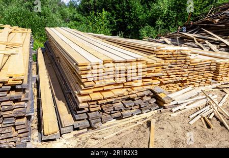 Stapel von Holzbrettern im Sägewerk. Lager zum Sägen von Brettern auf einem Sägewerk im Freien. Holzstapel aus Holzrohlingen aus Baumaterial Stockfoto