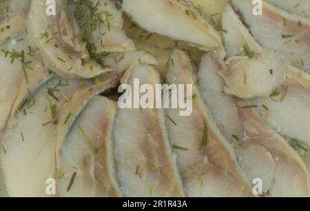 Hintergrund: Gesalzene und eingelegte Heringsfische in Scheiben. Gesalzener Hering in Öl Stockfoto