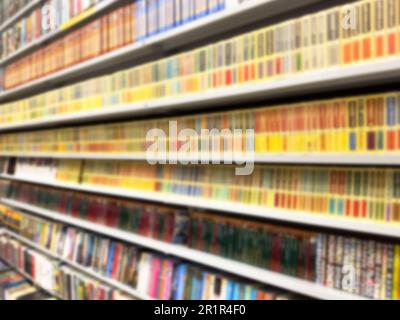 Abstrakte, verschwommene, moderne, weiße Bücherregale mit Büchern. Verwischen Sie Handbücher und Lehrbücher auf Bücherregalen in der Bibliothek oder im Buchladen. Bildungskonzept. Li Stockfoto