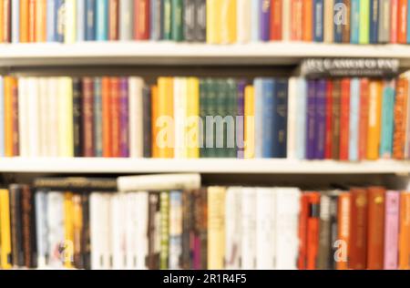 Abstrakte, verschwommene, moderne, weiße Bücherregale mit Büchern. Verwischen Sie Handbücher und Lehrbücher auf Bücherregalen in der Bibliothek oder im Buchladen. Bildungskonzept. Li Stockfoto