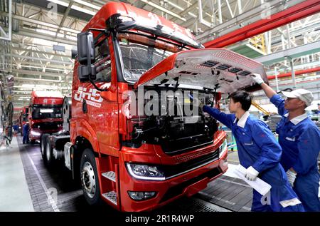 QINGDAO, CHINA - 15. MAI 2023 - Arbeiter testen Fahrzeuge, die in der Montagewerkstatt eines Automobilunternehmens in Qingdao vom Band Rollen, Stockfoto