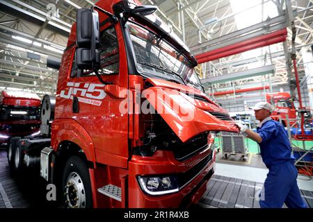 QINGDAO, CHINA - 15. MAI 2023 - Arbeiter bauen Fahrzeuge in der Endmontagewerkstatt eines Automobilunternehmens in Qingdao, der ostchinesischen Provinz Shandong Stockfoto