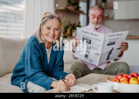 Seniorenpaar verbringt Freizeit zusammen in ihrem Wohnzimmer. Stockfoto