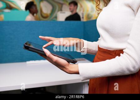 Nahaufnahme von freigestellten Händen beim Wischen auf einem digitalen Tablet, Kollegen im Büro Stockfoto