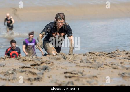 Vicki Riley, Gewinnerin kurz vor dem Ende des Maldon Mud Race in Maldon, Essex, Großbritannien, im Schlamm des Flusses Blackwater. Traditionelle Wohltätigkeitsveranstaltung Stockfoto