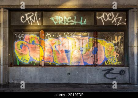 Mehrfarbige Graffiti, beleuchtet durch Reflexion durch die ersten Sonnenstrahlen. Brüssel. Stockfoto
