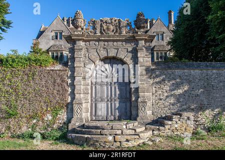 Cold Ashton, Chippenham, UK-August 2022; Nahaufnahme der von Mauern umgebenen Fassade eines Cold Ashton Herrenhauses mit verwitterter Holzeingangstür Stockfoto