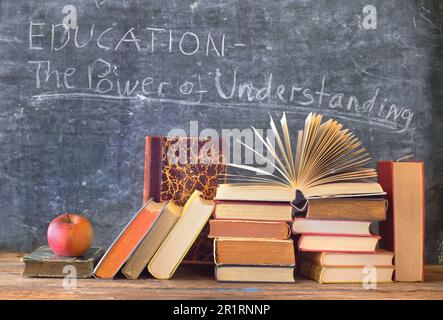 Ein Stapel Bücher mit Schriftzug vor einer Tafel. Lernen, Bildung, Lesen, zurück zur Schule Konzept. Stockfoto