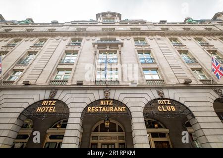 London - Mai 2023: Das Ritz London 5-Sterne-Luxushotel mit den berühmten schwarzen Londoner Taxis, die vor dem Haupteingang verschwommen sind. Stockfoto