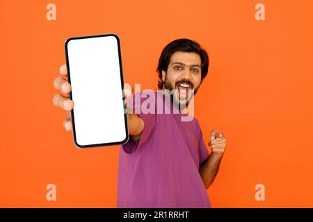 Ein emotionaler inder, der auf sein Smartphone in der Hand zeigt Stockfoto