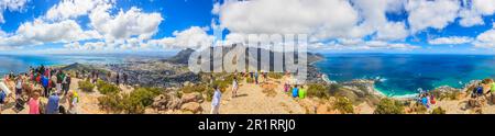 Panoramablick auf den Gipfel des Löwenkopfes mit Blick auf Kapstadt sowie Tafelberg und Camps Bay während des Tages mit blauem Himmel und weißer Wolke Stockfoto