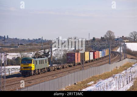 Am 10. Februar 2009 fährt eine elektrische Lokomotive der Klasse Freightliner der Klasse 90 mit der Nummer 90046 nach Norden auf einem schneebedeckten Soulbury. Stockfoto