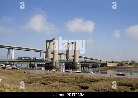 Ein Paar DRS-Diesellokomotiven der Klasse 37 mit den Nummern 37667 und 37510, die die Kingsferry Bridge in der Nähe von Swale mit einem Zug von Drehgestellwagen überqueren. Stockfoto