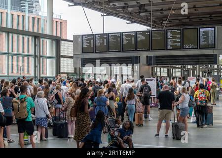 London, England - August 2022; Blick über die Bahnsteige voller Menschen, die auf die Abfahrt der Inlandszüge auf der oberen Ebene von St. Pancras warten Stockfoto