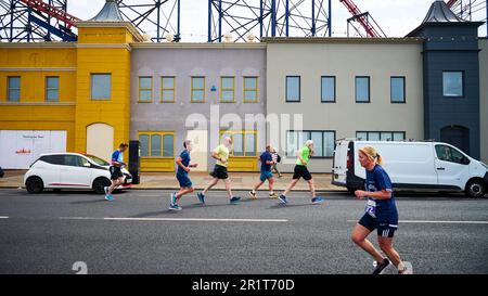 Die Teilnehmer des Blackpool 10 K Fun Run passieren den Pleasure Beach auf halbem Weg Stockfoto