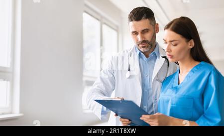 Teamarbeit im Gesundheitswesen. Männlicher Arzt und Assistenzarzt, der die Krankengeschichte des Patienten überprüft, mit Gespräch in der Krankenhauspraxis Stockfoto