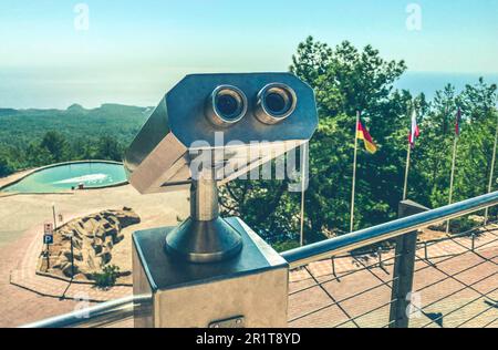 Optisches Gerät, Fernglas mit Panoramablick auf die Berge. Besichtigung der Umgebung aus der Höhe, lokale Schönheit. Vom Berg aus beobachten. Stockfoto