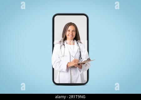 Moderne medizinische Dienste. Fröhliche ältere Ärztin, die dem Patienten ein Rezept ausstellt, und auf den großen Handybildschirm schaut Stockfoto