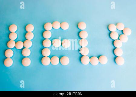 Wunderschöne Inschrift aus weißen runden, glatten medizinischen Pillen, Vitaminen, Antibiotika und Kopierraum auf hellblauem Hintergrund. Flach verlegt. Stockfoto