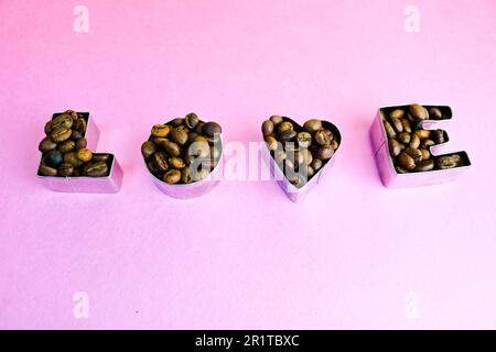 Wunderschöne Textur mit der Aufschrift „Liebe zum valentinstag“ aus gerösteten, ausgewählten braunen, natürlichen aromatischen Arabica-Kaffeebohnen, robusta C Stockfoto