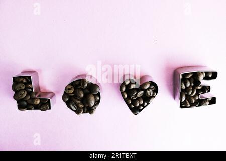 Wunderschöne Textur mit der Aufschrift „Liebe zum valentinstag“ aus gerösteten, ausgewählten braunen, natürlichen aromatischen Arabica-Kaffeebohnen, robusta C Stockfoto