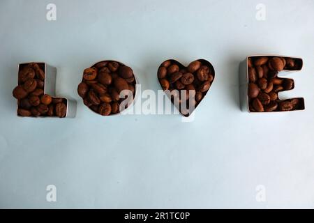Wunderschöne Textur mit der Aufschrift „Liebe zum valentinstag“ aus gerösteten, ausgewählten braunen, natürlichen aromatischen Arabica-Kaffeebohnen, robusta C Stockfoto