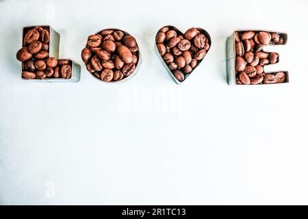 Wunderschöne Textur mit der Aufschrift „Liebe zum valentinstag“ aus gerösteten, ausgewählten braunen, natürlichen aromatischen Arabica-Kaffeebohnen, robusta C Stockfoto