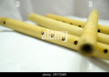 Eine Flöte mit Löchern liegt auf einem weißen Tuch. Nepali Bamboo Flöte Basuri Stockfoto
