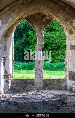 Ein zerstörtes Fenster in Waverley Abbey bei Farnham Surrey. Die Abtei war die erste Zisterzienserabtei, die 1128 in England gegründet wurde. Stockfoto