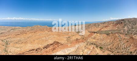Die wunderschöne Einöde des Skazka Canyon mit dem Issyk-Kul-See im Hintergrund in Kirgisistan. Stockfoto