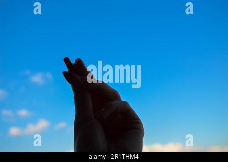 Schöne weibliche Hand hält eine medizinische pharmazeutische Pille Kapsel aus dem Coronavirus covid-19 für die Behandlung von Krankheiten und Viren auf einem blauen Himmel Ba Stockfoto