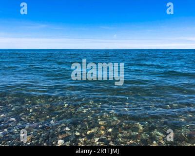Wunderschöne mehrfarbige runde Steine am Meer, Flüsse, Seen, Teich, Meer und kochendes Wasser mit Wellen am felsigen Strand eines tropischen warmen Resorts Stockfoto