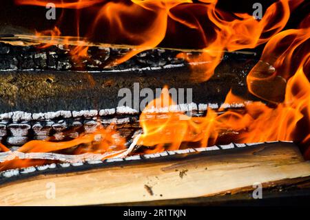 Brennende, heiße Holzplanken mit Feuer und Rauch. Textur, Hintergrund. Stockfoto