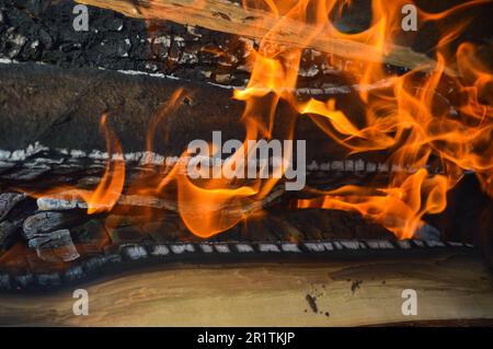 Brennende, heiße Holzplanken mit Feuer und Rauch. Textur, Hintergrund. Stockfoto