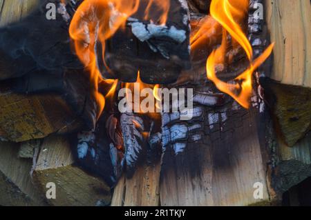 Brennende, heiße Holzplanken mit Feuer und Rauch. Textur, Hintergrund. Stockfoto