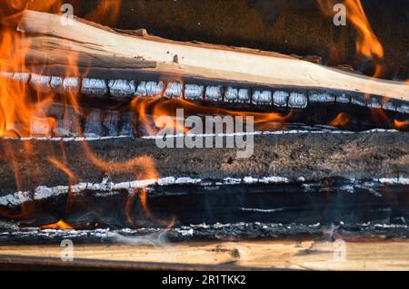 Brennende, heiße Holzplanken mit Feuer und Rauch. Textur, Hintergrund. Stockfoto