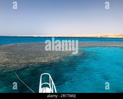 Die Nase, die Vorderseite der weißen Yacht, das Boot, das Schiff, das auf dem Jig steht, Parken, Anker im Meer, das Meer mit blauem Wasser mit Korallen Stockfoto