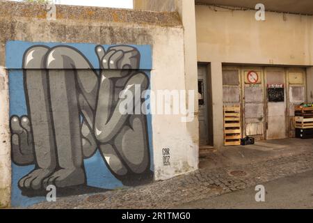 Ein Wandgemälde eines sitzenden Mannes an einer Wand, Altstadt, Lagos, Algarve, Portugal Stockfoto