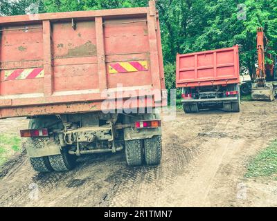 Ein Lkw mit Aufbau für den Transport schwerer Gegenstände. Aufkleber für schwere Nutzfahrzeuge auf der Rückseite der Karosserie. Das Auto fährt auf einer schlammigen Straße und hinterlässt Reifen Stockfoto