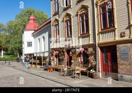 Café, Restaurant in traditionellem Holzgebäude in Allmanna Vagen mit Matteus Kyrkan (Kirche) in Mallorna im Hintergrund. Göteborg. Stockfoto