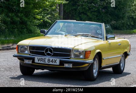 Stoke Goldington, Northants, Großbritannien - Mai 14. 2023. 1982 gelber MERCEDES-BENZ SL-Oldtimer, der durch ein englisches Dorf fährt Stockfoto