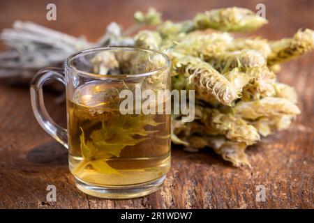 griechischer Sideritis-Tee auf dunklem Holz Stockfoto